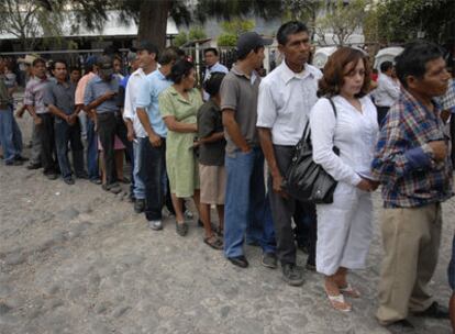 Una fila de personas espera para votar en Panchimalco, 17 km al sur de la capital, San Salvador, en las elecciones presidenciales que se celebran hoy.