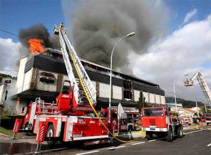 Los bomberos se emplean en la extinción del incendio.