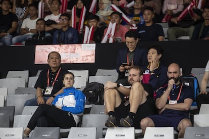 Mientras sus rivales juegan, Carolina sigue el torneo desde la grada junto a Anders Thomsen (entrenador) y Nacho Sarria (fisio).