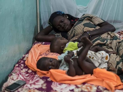 Una madre desansa junto a sus dos hijss aquejados de malnutrición en la Unidad Nutricional Intensiva del hospital Dioila el 7 de noviembre de 2016 en Dioila, Malí.
