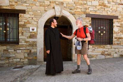 El monje Juan Antonio Torres atiende a un peregrino italiano en el monasterio de San Salvador de Monte Irago, en Rabanal del Camino.