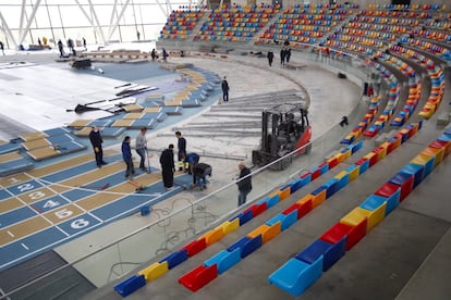 Varios operarios trabajan desmontando la pista cubierta de atletismo de Sabadell para montar un hospital de campaña con capacidad para 300 plazas, este martes.