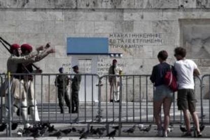 Varios turistas observan el cambio de guardia presidencial en la Tumba del Soldado Desconocido, en Atenas. EFE/Archivo