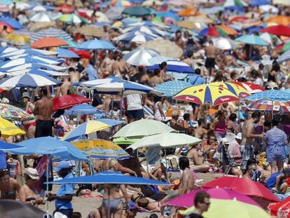 Un gran n&uacute;mero de personas disfrutan del buen tiempo estival en la playa de la Malvarrosa, en Valencia. 