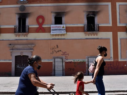 Tres mujeres caminan frente al Palacio Municipal de Fresnillo, Zacatecas, quemado tras una protesta por el feminicidio de una menor.