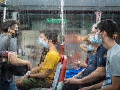 Usuarios del transporte público, en el paseo de Gràcia de Barcelona en agosto.