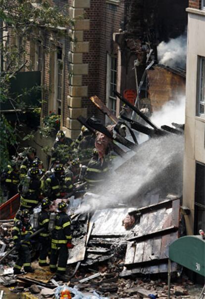 Un grupo de bomberos tratan de apagar el fuego que ha provocado el derrumbe de un edificio en el barrio neoyorquino de Manhattan.