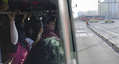 Varios ciudadanos viajan a bordo de un autobús de la empresa TransMilenio, en Bogotá.