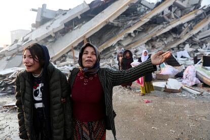 Women react near rubble following an earthquake in Hatay, Turkey.