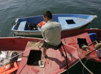 Un guardia civil inspeccionaba ayer la nueva patera llegada a la zona del Cabo de Huertas, en Alicante.