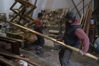 Carpinteros preparando la madera con la que están forrando el barco.