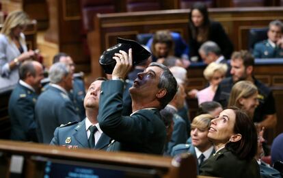 Algunos de los guardias civiles miran las marcas de bala que dejaron en el techo del hemiciclo los disparos realizados el 23-F.