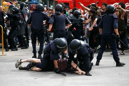 Los mossos reducen a un indignado durante el desalojo de la Plaza Catalunya de Barcelona.