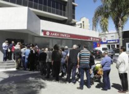 Varias personas hacen cola a las puertas de una sucursal de Laiki Bank en Limassol (Chipre).