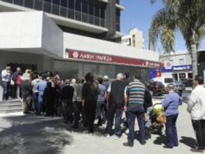 Varias personas hacen cola a las puertas de una sucursal de Laiki Bank en Limassol (Chipre).