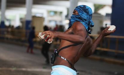 Un manifestante lanza piedras a la polica fuera de la estacin central de trenes, durante protesta contra el aumento en las tarifas de autobs en Ro de Janeiro, Brasil.