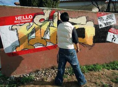 Un joven, ante un muro lleno de <i>graffiti</i> en Herrera Oria.