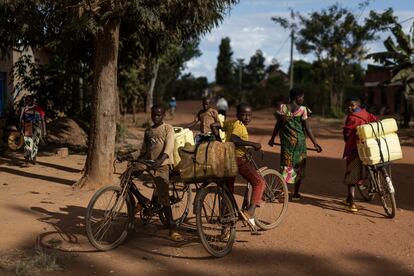 Varios adolescentes cargan bidones de agua en sus bicicletas, en el pueblo de Jurú, en Ruanda, donde se puso en marcha, en coordinación con las autoridades ruandesas, un programa de terapia de familias destinado a sanar el trauma social provocado por el genocidio de 1994.