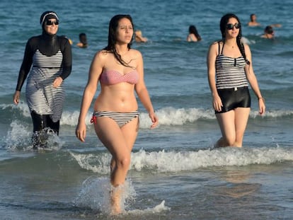 Mujeres tunecinas vistiendo burkini (izquierda), bikini (centro) y bañador en las playas de Bizerta.
