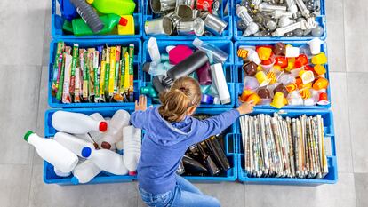 Una niña separa los residuos para luego reciclarlos.