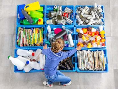 Una niña separa los residuos para luego reciclarlos.