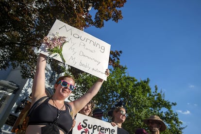 Una manifestante por el clima sostiene una pancarta en la que se lee: "De duelo por mi planeta, mi democracia, mi autonomía corporal". 