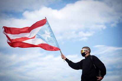 El cantante puertorriqueño de reguetón, Bad Bunny, ondea una bandera de Puerto Rico durante una protesta para exigir la renuncia del gobernador Ricardo Rossello en San Juan (Puerto Rico), el 17 de julio de 2019. Este miércoles, miles de personas marcharon por quinto día consecutivo exigiendo la renuncia de Ricardo Rossello, tras las acusaciones de corrupción y la filtración de chats de texto en los que hizo comentarios sexistas y homófobos.