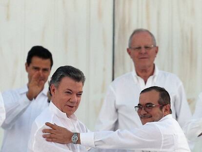 El presidente colombiano, Juan Manuel Santos, a la izquierda, y el líder de las FARC, Timochenko, tras firmar la paz el lunes en Cartagena de Indias.