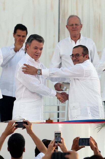 El presidente colombiano, Juan Manuel Santos, a la izquierda, y el líder de las FARC, Timochenko, tras firmar la paz el lunes en Cartagena de Indias.