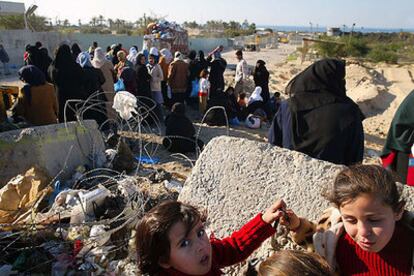Mujeres y niñas palestinas ante el control militar que separa Muasai del campo de refugiados de Jan Yunis.