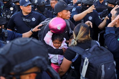 Este lunes, la policía de Ciudad Juárez desalojó un campamento ubicado junto a la presidencia municipal de la ciudad. Ese mismo día, inició operaciones el nuevo refugio. En la imagen, un migrante resguarda a su hija durante el el desmantelamiento del campamento en la ciudad fronteriza. 
