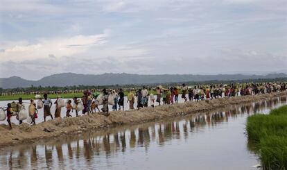 Musulmanes rohingya cargan con sus pertenencias hacia un campo de refugiados en Palong Khali (Bangladés), el 19 de octubre de 2017.