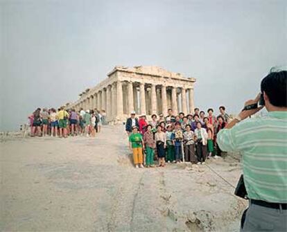 Un grupo de turistas se fotografía en el Partenón, el templo de orden dórico construido en la Acrópolis en el siglo V antes de Cristo por Ictinos de Mileto y Calícrates, supervisados por Fidias.