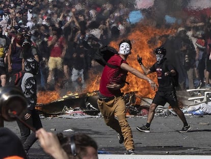 Un joven lanza piedras contra la policía durante una protesta en Santiago de Chile.