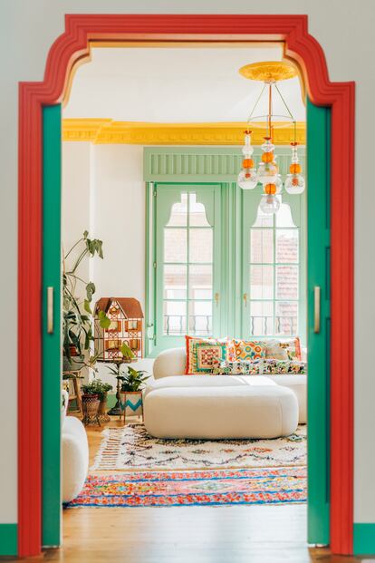 Vista del salón desde el estudio. La puerta corredera que los conecta no estaba; es un añadido que se hizo replicando el diseño de las ventanas. El sofá es de Westwing. Una de las alfombras es de Sklum y la otra la compró en Marruecos. La lámpara la ha hecho ella misma.