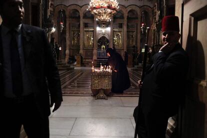 Una mujer ortodoxa enciende una vela dentro de la capilla griega de la Iglesia del Sagrado Sepulcro, en Jerusalén.