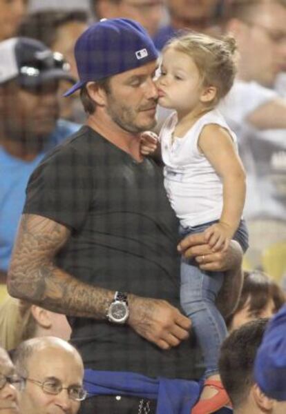 Harper Beckham besa a su padre durante un partido de b&eacute;isbol, el 27 de agosto de 2013.