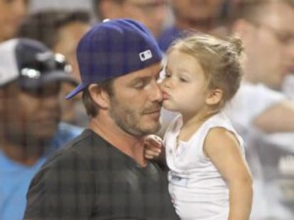 Harper Beckham besa a su padre durante un partido de b&eacute;isbol, el 27 de agosto de 2013.