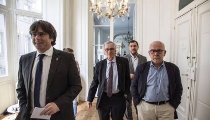 Xavier Trias (centro), rodeado del expresidente Carles Puigdemont (izq.), el exconsejero Toni Comín y el abogado Gonzalo Boye (der.).