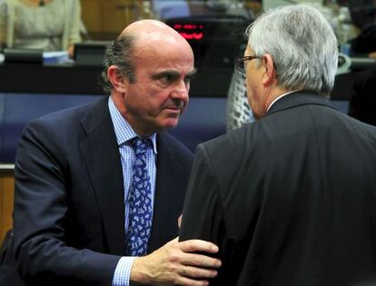 Luis de Guindos, conversa con el presidente del Eurogrupo, Jean Claude Juncker.