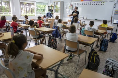 Un profesor explica a los niños como lavarse las manos durante el primer día de clase en el inicio del curso escolar en Valencia.