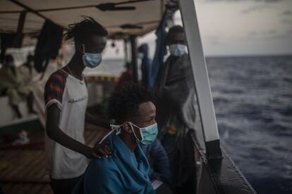 Migrantes de diferentes nacionalidades descansan a bordo del barco de la ONG española 'Open Arms', tras ser rescatados el martes cuando intentaban huir de Libia.