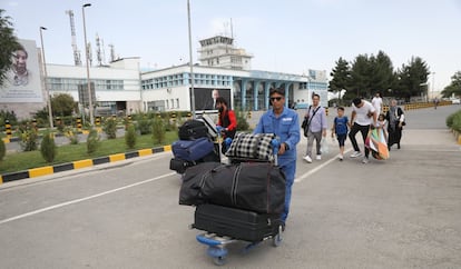 Os passageiros caminham para o terminal o Aeroporto Internacional Hamid Karzai, em Cabul.