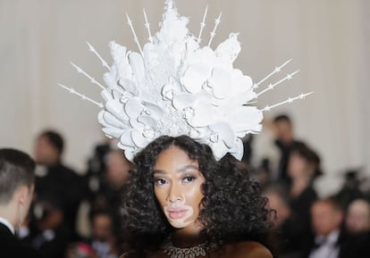 La modelo Winnie Harlow con un tocado blanco con flores de porcelana.