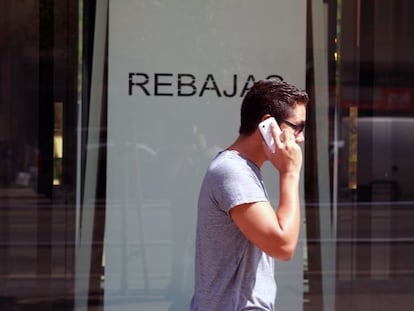 Un joven habla con su móvil en una calle de Madrid.