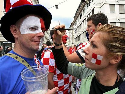 Aficionados croatas se pintan la cara antes de un partido.