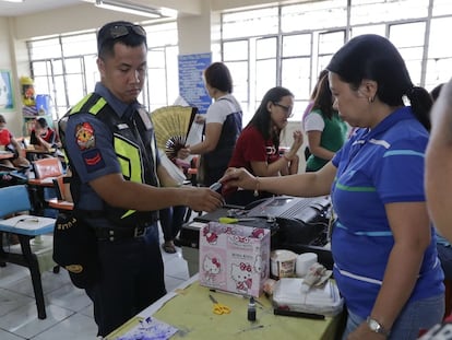 Un policía deposita su vota en la urna en Manila, Filipinas.