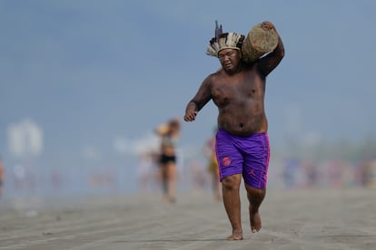 El jefe indígena Awa Tenondegua, de la etnia tupí guaraní, compite en una carrera de relevos con troncos en la playa de Peruibe durante los Juegos indígenas.