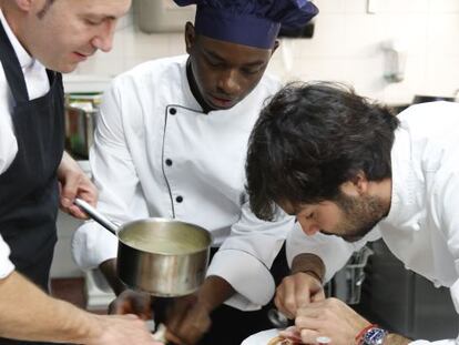 El chef Javier Muñoz Calero (a la derecha) remata un plato con su ayudante de cocina Yossouf Diarra.