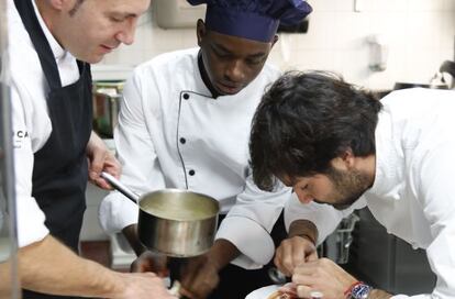 El chef Javier Muñoz Calero (a la derecha) remata un plato con su ayudante de cocina Yossouf Diarra.